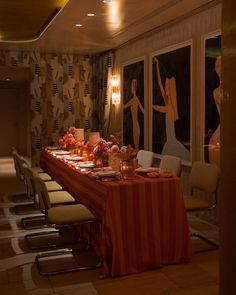 a long table is set up in the middle of a room with chairs and tables