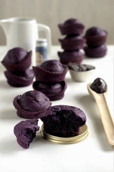 purple cupcakes are sitting on a table next to a spoon