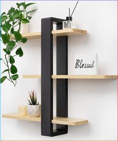 three wooden shelves with plants on them and a sign that says blessing hanging from the wall