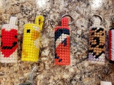 four crocheted lighters are sitting on a counter top next to each other