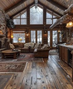 a living room filled with furniture and a fire place in the middle of a wooden floor