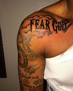 a man with a tattoo on his arm that says fear god and an eagle in the sky