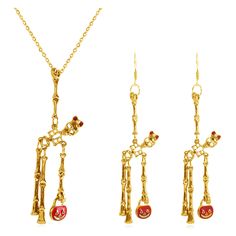 three gold necklaces with red beads and chains hanging from the neck, on a white background