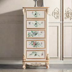 an ornate chest of drawers with flowers painted on the front and sides, against a white wall