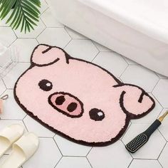 a pink rug with a pig face on it next to slippers and a brush