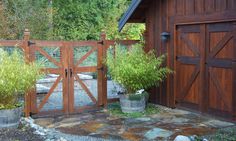 a wooden building with a gate and potted plants