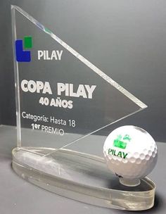 a glass trophy with a golf ball on it and the words'play'in spanish