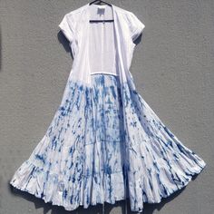 a blue and white dress hanging up against a gray wall with an umbrella attached to it