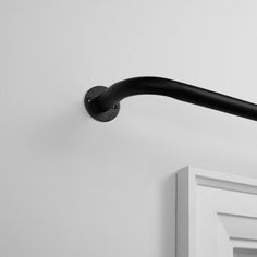 a black and white photo of a door handle on a wall in a room with no one around it