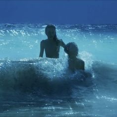 two children are playing in the ocean water