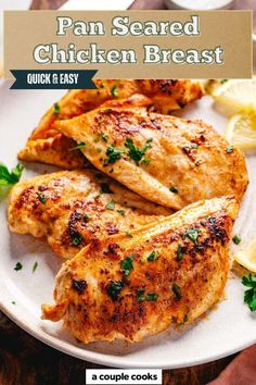 the pan seared chicken breast is on a plate with lemons and parsley