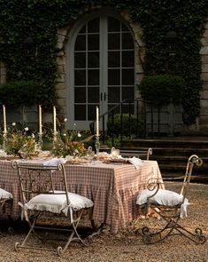 a table set up outside with candles and flowers