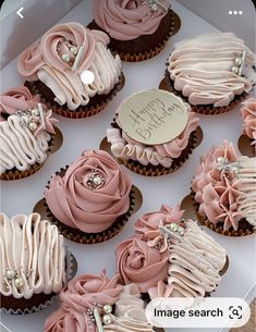 a box filled with lots of pink cupcakes on top of a white table