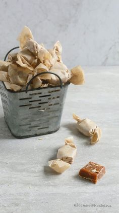 a metal basket filled with lots of food next to a pile of cashews