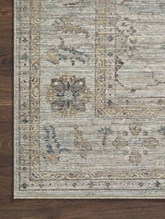 an area rug with various colors and designs on the floor, including blue, beige and green