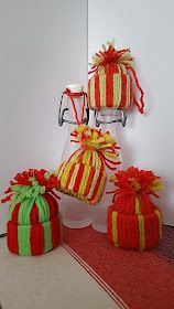 three knitted gift bags sitting next to each other on a red and white table