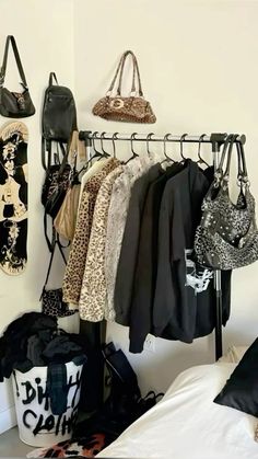 there are many purses and handbags hanging on the rack in this room,