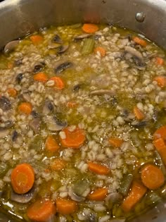 a pot full of soup with carrots and mushrooms