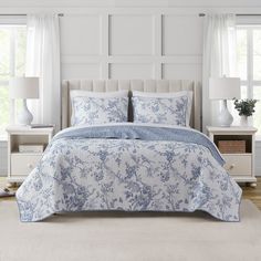 a bed with blue and white comforters in a bedroom