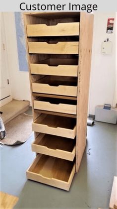 a large wooden cabinet with drawers on the top and bottom shelves in front of it