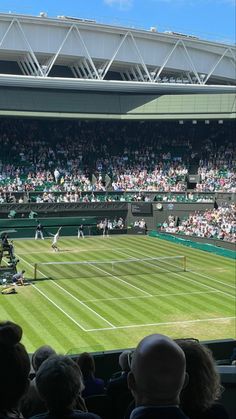 a tennis match is being played in front of an audience