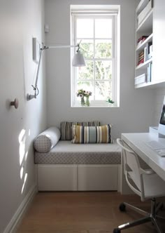 a white room with a window seat and desk