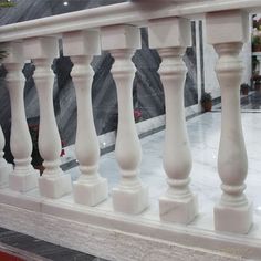 a white balcony railing with flowers in the background