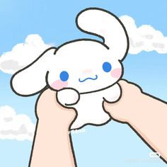 a person holding up a stuffed animal in front of a blue sky with white clouds