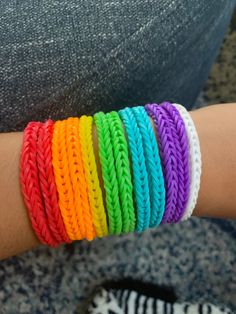 a woman's arm with several different colored bracelets on it