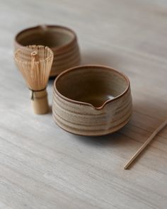 two small wooden bowls sitting on top of a table next to a pair of chopsticks