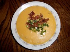 a white plate topped with soup and bacon