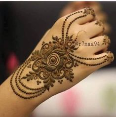 the hand is decorated with henna and beads