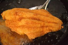 fried food being cooked in a frying pan with a spoon sticking out of it