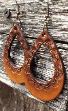 A simple, Southwest-inspired design decorates the rich leather in this beautiful pair of earrings.  Crafted by hand from start to finish, each set starts out as blank slates of premium veg-tanned leather. From there I hand-tool and dye the leather for truly unique, one-of-a-kind earrings. No two pair are alike. These earrings are conditioned with beeswax, which keeps the leather supple and water resistant (as seen in video). Edges and backs are finished, as well. Please remember that time and we Leather Designs Pattern, Simple Leather Tooling Patterns, Leatherwork For Beginners, Handmade Earrings For Everyday Use, Hand Tooled Leather Earrings, Artisan Leather Jewelry, Brown Teardrop Jewelry For Everyday Wear, Handmade Leather Dangle Earrings, Everyday Brown Teardrop Earrings For Pierced Ears