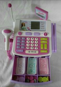 a pink and white calculator sitting on top of a bed next to a phone