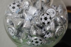 a glass jar filled with chocolate candies covered in soccer balls and letters on them