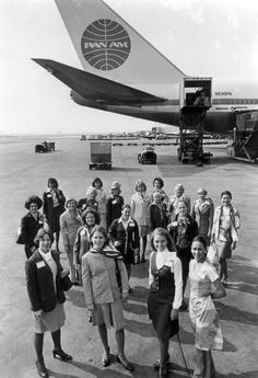 a group of women standing in front of an airplane