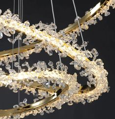 a large chandelier with many lights hanging from it's sides and gold rings