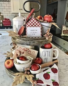 a basket filled with apples sitting on top of a kitchen counter next to other items