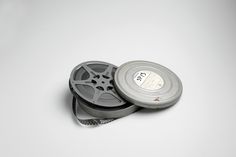 two film reels sitting next to each other on a white surface with one being cut off