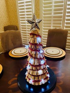 a christmas tree made out of crackers sitting on top of a wooden dining table