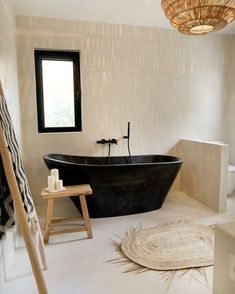 a black bath tub sitting in a bathroom next to a window