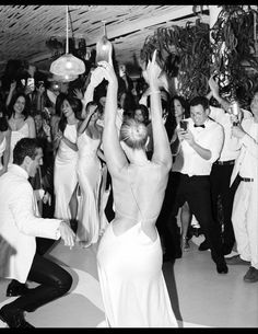 a black and white photo of people dancing on the dancefloor at a wedding