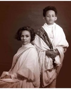 an old photo of two women dressed in native garb, one holding a baby