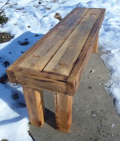 a wooden bench sitting on top of snow covered ground