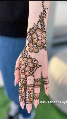 a woman's hand with henna tattoos on it