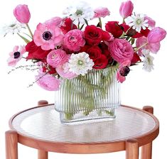 a vase filled with lots of pink and white flowers