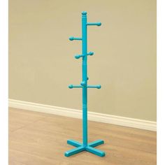 a blue coat rack stands on the floor in front of a beige wall and hardwood floor