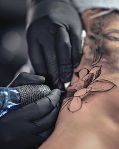 a woman getting a tattoo done on her stomach