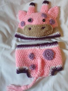 two crocheted hats and diaper covers on a white sheet with pink flowers